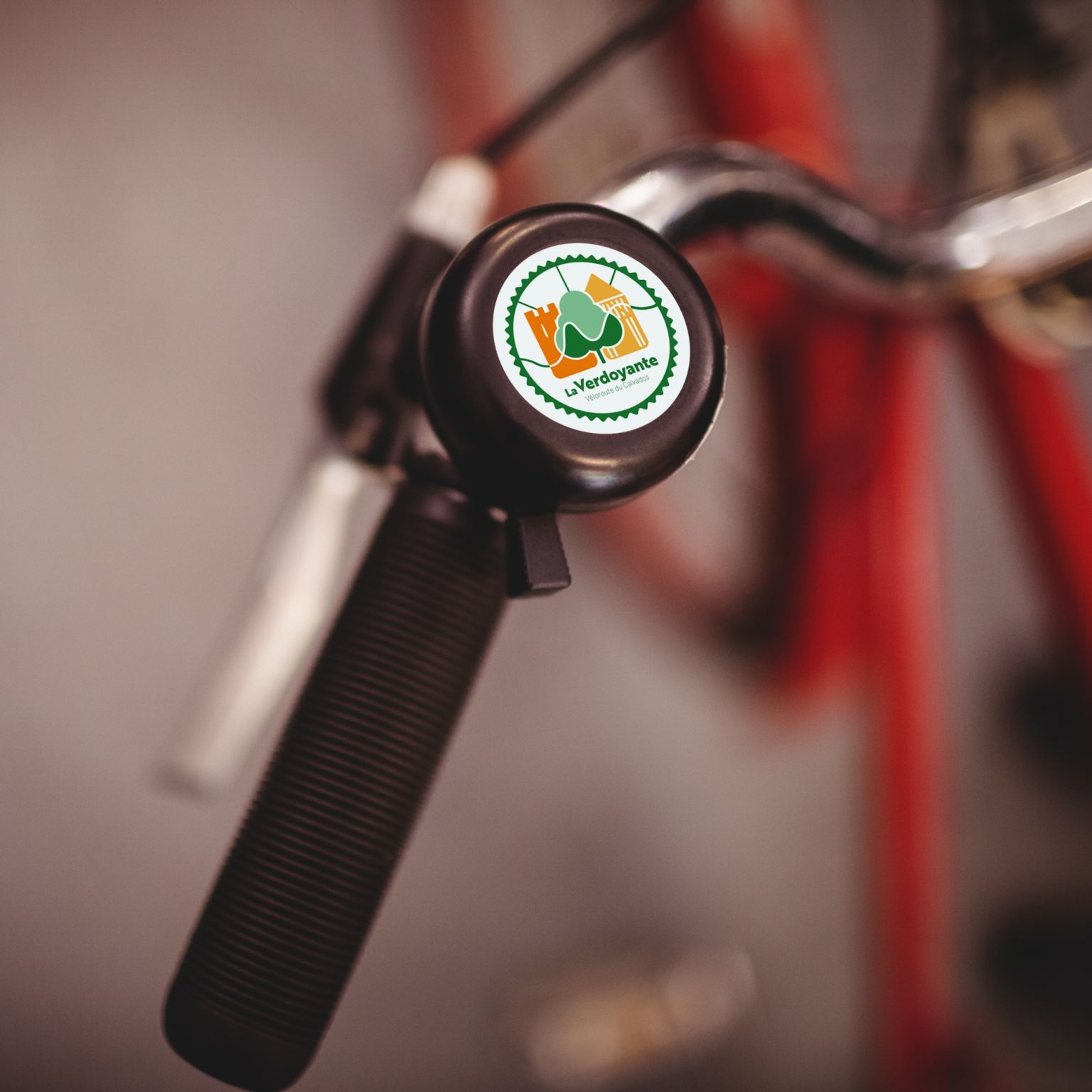 Photo d'une sonnette de vélo avec le logo de la Verdoyante - Véloroute du Calvados