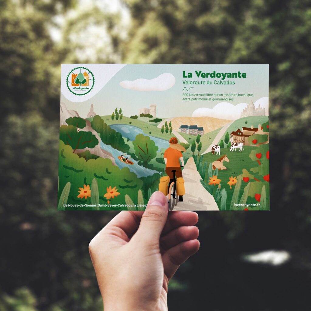 Photo d'une main tenant le flyer de la Verdoyante - Véloroute du Calvados