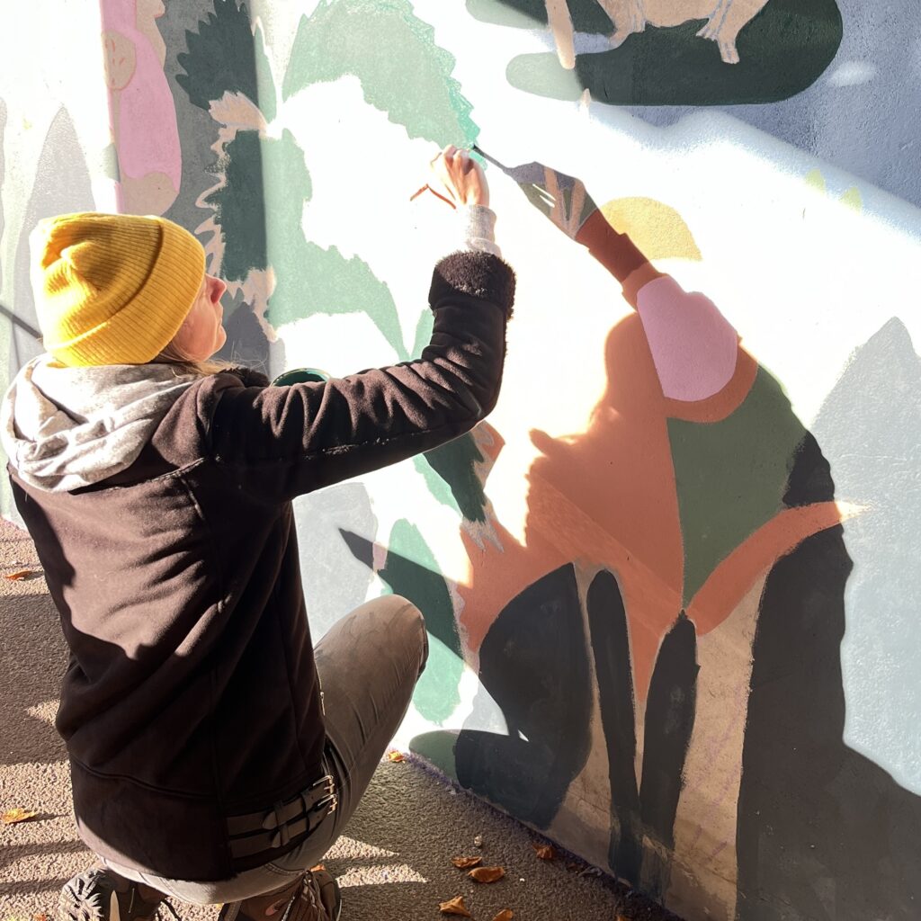 Photo d'une peintre en train de faire une fresque