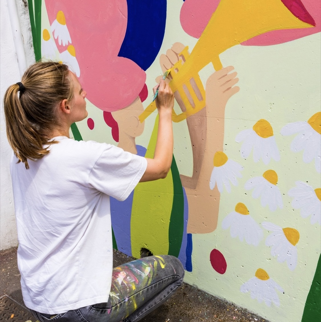 Photo d'une peintre muraliste en train de réaliser une fresque à Mondeville